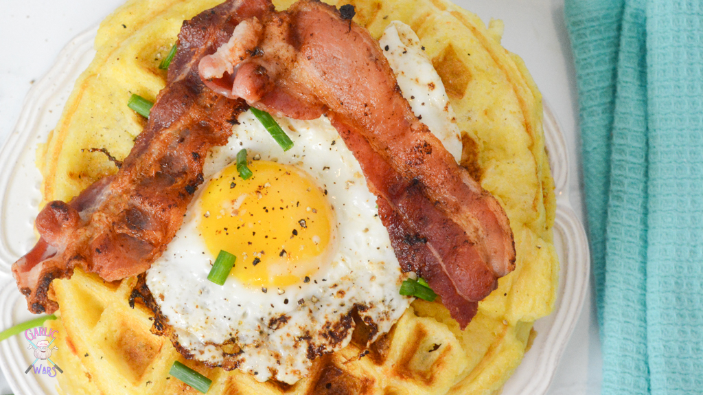 Waffles with a fried egg and bacon on top.