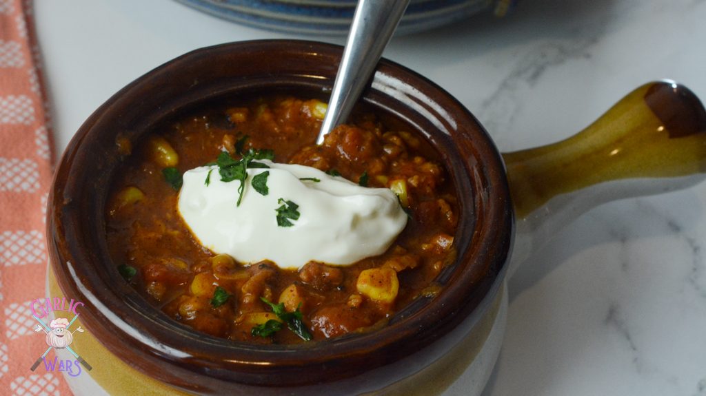 small bowl of pumpkin chili topped with sour cream