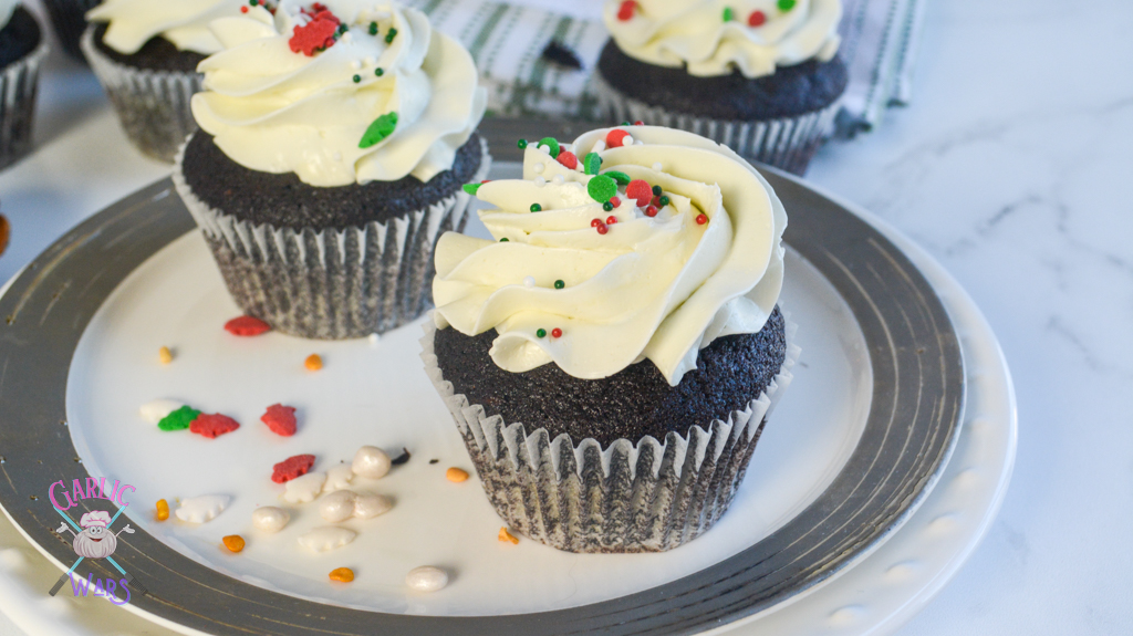 two cupcakes on a plate with holiday sprinkles