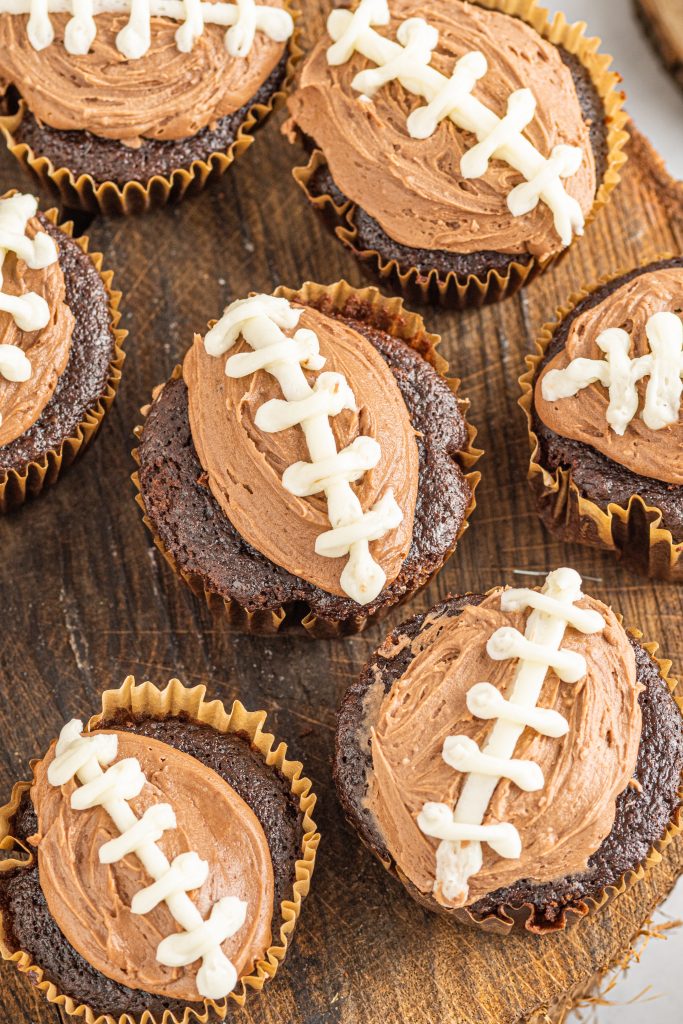chocolate cupcakes on wooden board with football design